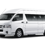 Toyota Hiace Commuter putih tampak serong depan dan samping untuk layanan sewa Hiace Bandung dengan driver profesional