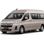 Toyota Hiace Premio coklat muda metallic tampak serong depan dan samping untuk layanan sewa Hiace Bandung dengan driver profesional